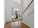 Bright foyer featuring hardwood floors, a staircase with wooden railing, and a large glass front door at 8240 Knollbrook Ln, Mcdonough, GA 30253