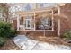 Inviting front porch with white columns, ample seating, and a charming tree, creating a cozy outdoor space at 8240 Knollbrook Ln, Mcdonough, GA 30253