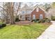 Beautifully landscaped front yard featuring lush green lawn, mature trees, and a brick facade at 8240 Knollbrook Ln, Mcdonough, GA 30253