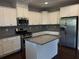 Modern kitchen with island, granite counters, and stainless appliances at 1890 Cobblefield Cir, Dacula, GA 30019