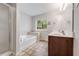 Bright bathroom featuring tile floors, garden tub, separate glass shower, and double sink vanity at 2166 Waterford Park Dr, Lawrenceville, GA 30044