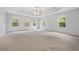 Large bedroom featuring tray ceilings, neutral walls, carpet, and large windows providing ample natural light at 2166 Waterford Park Dr, Lawrenceville, GA 30044