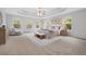 Bright bedroom featuring tray ceilings, neutral walls, carpet, and large windows providing ample natural light at 2166 Waterford Park Dr, Lawrenceville, GA 30044
