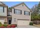 Charming brick townhome featuring black shutters, attached garage, and well-maintained landscaping at 2166 Waterford Park Dr, Lawrenceville, GA 30044