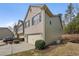 Side view of a townhome with a two-car garage, manicured lawn, and mature trees at 2166 Waterford Park Dr, Lawrenceville, GA 30044