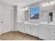 Elegant bathroom with double vanity, light wood floors, and a large window at 1057 Climbing Rose Way, Mcdonough, GA 30253