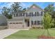 Two-story house with gray siding, double garage, and landscaped lawn at 1057 Climbing Rose Way, Mcdonough, GA 30253