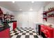 Finished basement area featuring a wet bar with red accents, black countertops, and checkered floor at 4086 Haverhill Dr, Atlanta, GA 30342