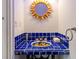 Unique powder room featuring blue tile, sunflower sink, and a sunburst mirror at 4086 Haverhill Dr, Atlanta, GA 30342