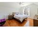 Sunlit bedroom boasts hardwood floors, a large window with sheer curtains, and a cozy bed with soft bedding at 4086 Haverhill Dr, Atlanta, GA 30342