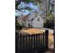 Charming two-story white home with a spacious driveway and inviting curb appeal enhanced by black fence and a basketball court at 4086 Haverhill Dr, Atlanta, GA 30342