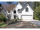 Charming two-story home with white exterior, arched windows, manicured lawn, and two car garage at 4086 Haverhill Dr, Atlanta, GA 30342