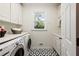 Clean laundry room featuring modern appliances, white cabinets, and patterned tile flooring at 4086 Haverhill Dr, Atlanta, GA 30342