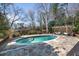 Backyard pool with stone patio, wooden deck, and pergola-covered seating area at 4086 Haverhill Dr, Atlanta, GA 30342