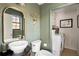 Powder room with green walls, trendy mirror, and a view into the laundry room at , Tucker, GA 30084