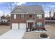 Two-story brick home with a three-car garage and landscaped yard at 3573 Stonebranch Ln, Loganville, GA 30052