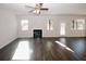 Bright living room with a modern fireplace, ceiling fan, and beautiful hardwood flooring at 3573 Stonebranch Ln, Loganville, GA 30052