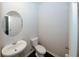 Compact powder room featuring a pedestal sink, a round mirror, and a modern toilet in a neutral color scheme at 3573 Stonebranch Ln, Loganville, GA 30052