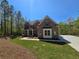 Charming brick two-story home with a covered front porch, green lawn, and a paved driveway leading to the property at 7449 Waterview Cv, Douglasville, GA 30135