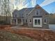 Two-story brick home featuring a covered porch, gray shutters, and a driveway, surrounded by a wooded area at 7449 Waterview Cv, Douglasville, GA 30135