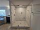 Walk-in shower with frameless glass enclosure and marble tile at 7449 Waterview Cv, Douglasville, GA 30135