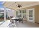 Covered patio with seating area, ceiling fan, and glass-top table at 201 Little River Way, Woodstock, GA 30188