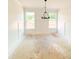 Bright dining room with wainscoting, two windows and a modern chandelier at 1275 Pj East Rd, Covington, GA 30014