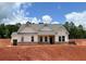 New construction home with a brick foundation, light siding, and a gray shingled roof sits on a bare lot at 1275 Pj East Rd, Covington, GA 30014