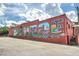 Red brick building with a large mural depicting 'Welcome to Monroe Downtown' at 1275 Pj East Rd, Covington, GA 30014