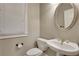 Clean powder room with pedestal sink, toilet, and oval mirror at 1215 Wynridge Xing, Alpharetta, GA 30005