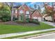 Two-story house with a brick facade, attached garage, and manicured lawn at 1215 Wynridge Xing, Alpharetta, GA 30005