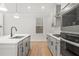 Modern kitchen with gray cabinets, stainless steel appliances, and quartz countertops at 731 Stickley Oak Way, Woodstock, GA 30189