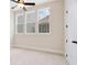 Well-lit bedroom with carpeted floors and three large windows at 89 Batten Board Way, Woodstock, GA 30189