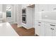 White kitchen with built-in oven and microwave, hardwood floors at 89 Batten Board Way, Woodstock, GA 30189