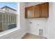 Bright laundry room with wood cabinets and backyard view at 89 Batten Board Way, Woodstock, GA 30189