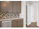 Modern wet bar with gray cabinets and hexagon tile backsplash at 89 Batten Board Way, Woodstock, GA 30189