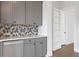 Modern wet bar with gray cabinets and hexagon tile backsplash at 89 Batten Board Way, Woodstock, GA 30189