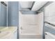 Bathroom with a tub and shower combination, light blue walls and white vanity and toilet at 1016 Old Holcomb Bridge Rd, Roswell, GA 30076