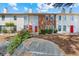 Townhomes with a red door, brick and vinyl siding with a large rock in a landscaped yard at 1016 Old Holcomb Bridge Rd, Roswell, GA 30076