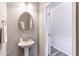 Elegant powder room with pedestal sink and oval mirror at 236 Hickory Commons Way, Canton, GA 30115