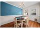 Charming dining area with hardwood floors, floral chairs, chandelier, and blue accent wall at 245 Winding River Dr # E, Atlanta, GA 30350