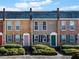 Brick townhomes featuring colorful doors, black shutters, and manicured landscaping at 245 Winding River Dr # E, Atlanta, GA 30350