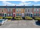 Brick townhomes with colorful doors and maintained landscaping with a parking area in front at 245 Winding River Dr # E, Atlanta, GA 30350