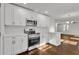 Bright kitchen with white cabinets, stainless steel appliances, and views to the living area at 1271 Lorenzo Sw Dr, Atlanta, GA 30310