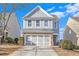 Two-story house with gray siding, brick accents, and a two-car garage at 2021 Lily Valley Dr, Lawrenceville, GA 30045