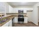 Well-equipped kitchen with white cabinets, stainless steel appliances, granite countertops and wood-look flooring at 3950 Fennel Sw Cir, Atlanta, GA 30331