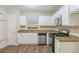 Bright kitchen featuring white cabinets, stainless steel appliances, granite countertops and wood-look flooring at 3950 Fennel Sw Cir, Atlanta, GA 30331