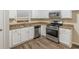 Well-lit kitchen featuring white cabinets, stainless steel appliances, granite countertops and wood-look flooring at 3950 Fennel Sw Cir, Atlanta, GA 30331