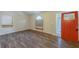 Bright living room with wood-look flooring, large windows, and a freshly painted orange entry door at 3950 Fennel Sw Cir, Atlanta, GA 30331