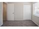 Bedroom with neutral walls, plush carpet, closet, and window with blinds, offering comfort and practicality at 3418 Longleaf Dr, Decatur, GA 30032